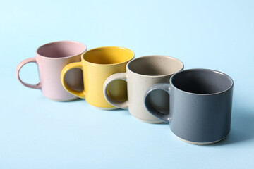 Set of ceramic mugs on color background