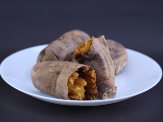 Sweet Potatoes on white plate with black background.