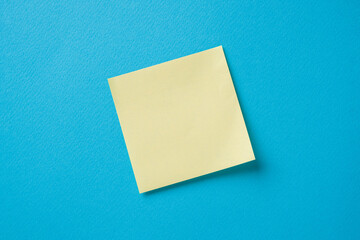 blank yellow sticky note on a blue background