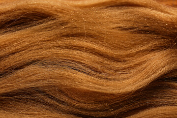 Naklejka premium Golden brown synthetic hair texture background wavy fibers for wig or extension material haircare and beauty industry, this material is commonly used for wigs hair extensions and other beauty products