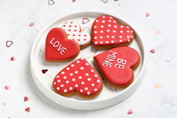 Plate with heart shaped cookies and decor on white grunge background. Valentine's day celebration