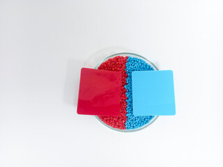 Masterbatch plastic, colorful polymer granules carrying pigments are poured into a glass cup with...