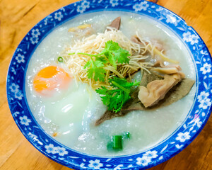 The photograph showcases a warm bowl of congee topped with a perfectly cooked egg.