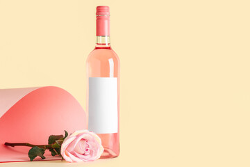 Bottle of pink wine and beautiful rose on colorful background