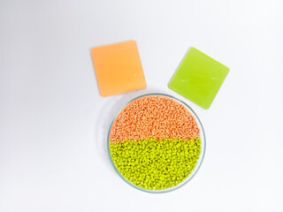 Masterbatch plastic, colorful polymer granules carrying pigments are poured into a glass cup with...