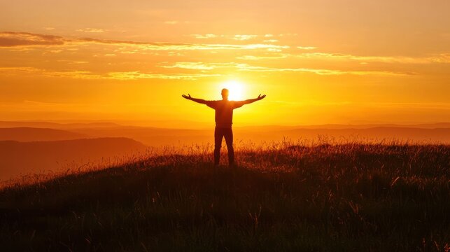 A person standing on a hill with their arms spread wide, looking proud and strong against the setting sun.
