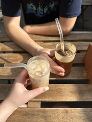 Two Iced coffee in glass cups. Man and woman drink iced coffee in a summer cafe. Vertical