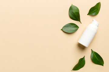 Organic cosmetic products with green leaves on color background. Copy space, flat lay