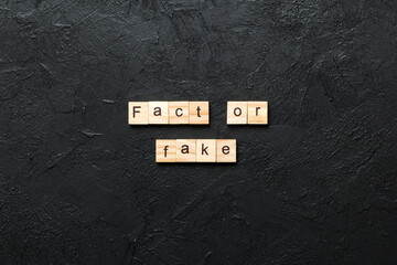 fact or fake word written on wood block. fact or fake text on table, concept