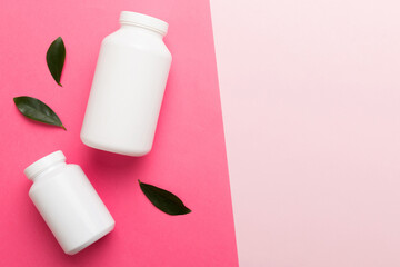 supplement pills with medicine bottle health care and medical top view. Vitamin tablets. Top view mockup bottle for pills and vitamins with green leaves, natural organic bio supplement, copy space