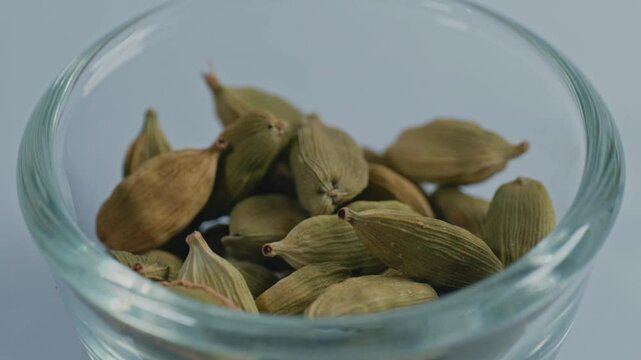 green elaichi or green cardamom in small glass bowl, 4k, parallax shot.