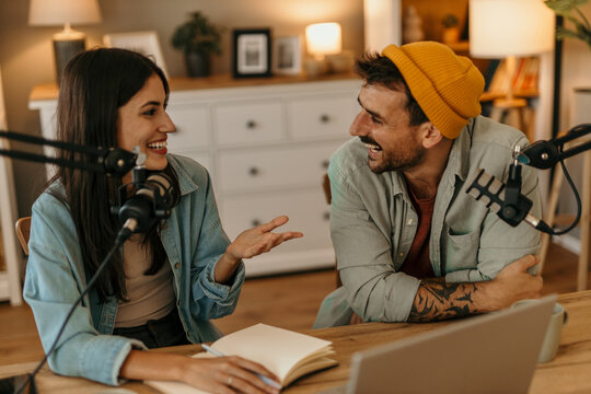 Bright and airy podcast studio with male and female co-hosts deep in discussion