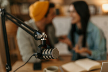 Co-hosts engaging in lively conversation during a podcast session in a modern studio