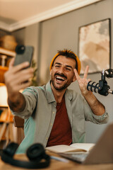 Smiling man hosting a podcast, speaking into a microphone in a bright space