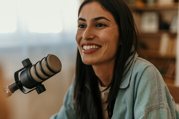 The confident woman hosting a podcast in a bright, modern studio.