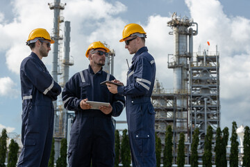 Engineer working using tablet together at station refining oil petrochemical. Technician worker check quality oil industry factory. Inspector standing at zone gas with refinery building background.