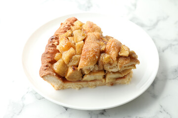 Slice of homemade apple pie on white marble table