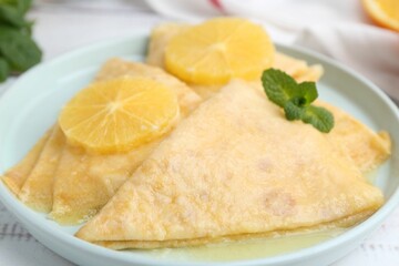 Delicious Crepes Suzette on white wooden table, closeup