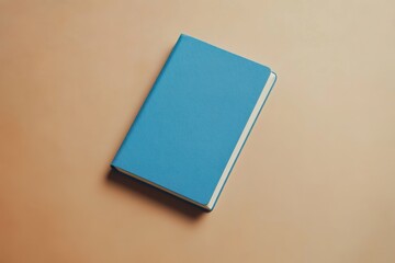Fototapeta premium Ice Blue Notebook Placed Elegantly on a Warm Beige Background for Stylish Notetaking