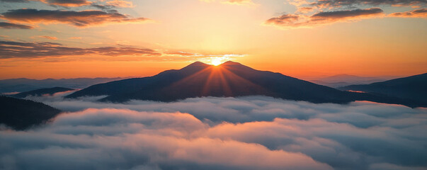 Stunning sunset over mountain range with clouds below