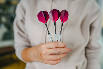 close up of woman handhold a pink dart ready for playing with them