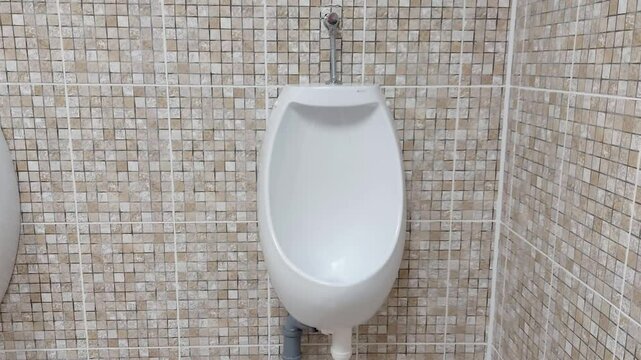 Wall-mounted men's urinal in a public toilet. The concept of cleanliness and hygiene in public toilets. Copy space for text, enuresis