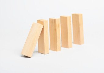 Domino effect. Wooden blocks falling on light background