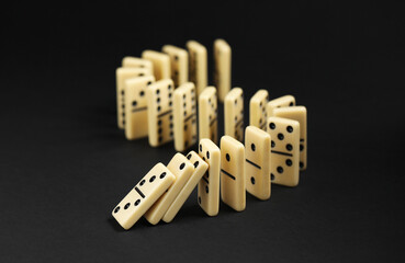 Domino effect. Tiles falling on black background