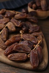 Tasty dried dates on wooden table, closeup