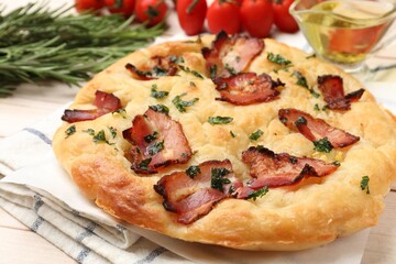 Delicious focaccia bread with bacon and parsley on white wooden table, closeup