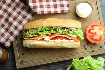Delicious baguette sandwich with salami and cheese on table, flat lay