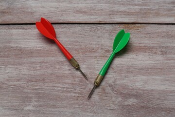 Colorful dart arrows on wooden rustic table, flat lay