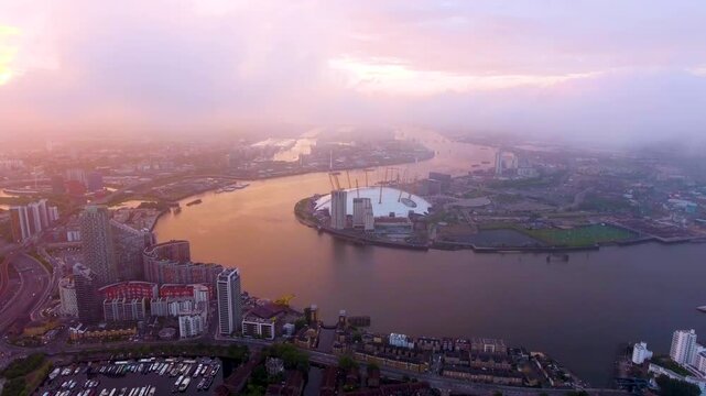 Mesmerizing aerial footage capturing a golden sunset over the O2 Arena and Thames River, showcasing London's urban charm and serene waterways.