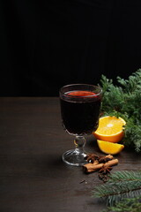 Red mulled wine on a wooden dark table among spice decor