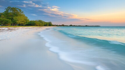 Fototapeta premium Serene sunset over tranquil beach with soft waves.