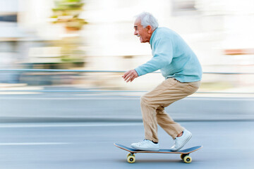 Elderly man enjoying a ride on a skateboard in casual attire