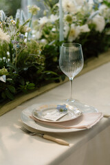 Modern stylish wedding table setting. The wedding decor. The pastel colors flowers bouquet. Natural beautiful wedding decorations. Minimalistic wedding decorations