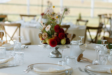 Modern stylish wedding table setting. The wedding decor. The pastel colors flowers bouquet. Natural beautiful wedding decorations. Minimalistic wedding decorations. Autumnal wedding table sitting