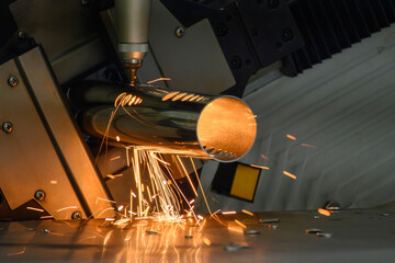 Close up scene the fiber laser cutting machine cut the stainless steel tube and sparkling light.