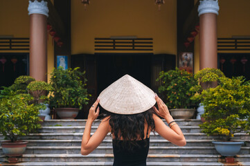 Chua Linh Ung in Da Nang, Vietnam. A female tourist wearing a Vietnamese Non La hat on the...