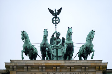 Obraz premium Bronze sculpture of Quadriga on top of the Brandenburg gate, famous landmark on the Pariser Platz in Berlin, Germany
