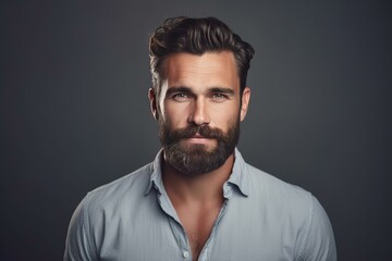 Obraz premium Studio portrait of a handsome businessman with a well groomed beard and hairstyle, exuding confidence against a gray backdrop