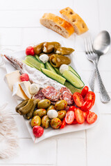 Assorted appetizer plater with salami, olives, vegetables and cheese