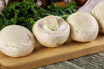 White champignon mushrooms heap over board