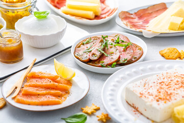 Assorted appetizers for brunch or party with salmon, cheese, salami and vegetables