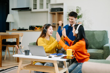  Group of young adults in casual wear, using laptops and headphones, enjoying teamwork, creativity, and learning