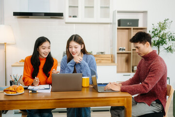 Teamwork and creativity with young adults collaborating on laptops and tablets in a cozy workspace.