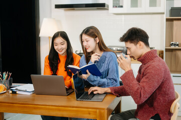 Teamwork and creativity with young adults collaborating on laptops and tablets in a cozy workspace.