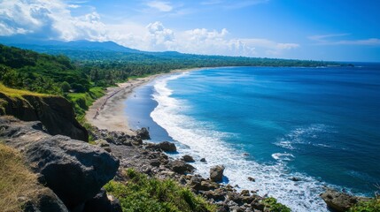 view of the beach from the top of the hill with rocks and blue sky.