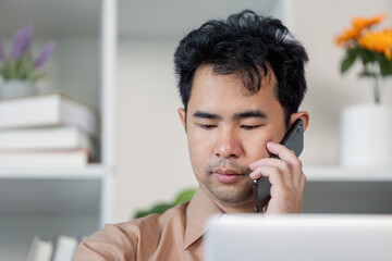 Businessman engaged in phone conversation while working in modern office